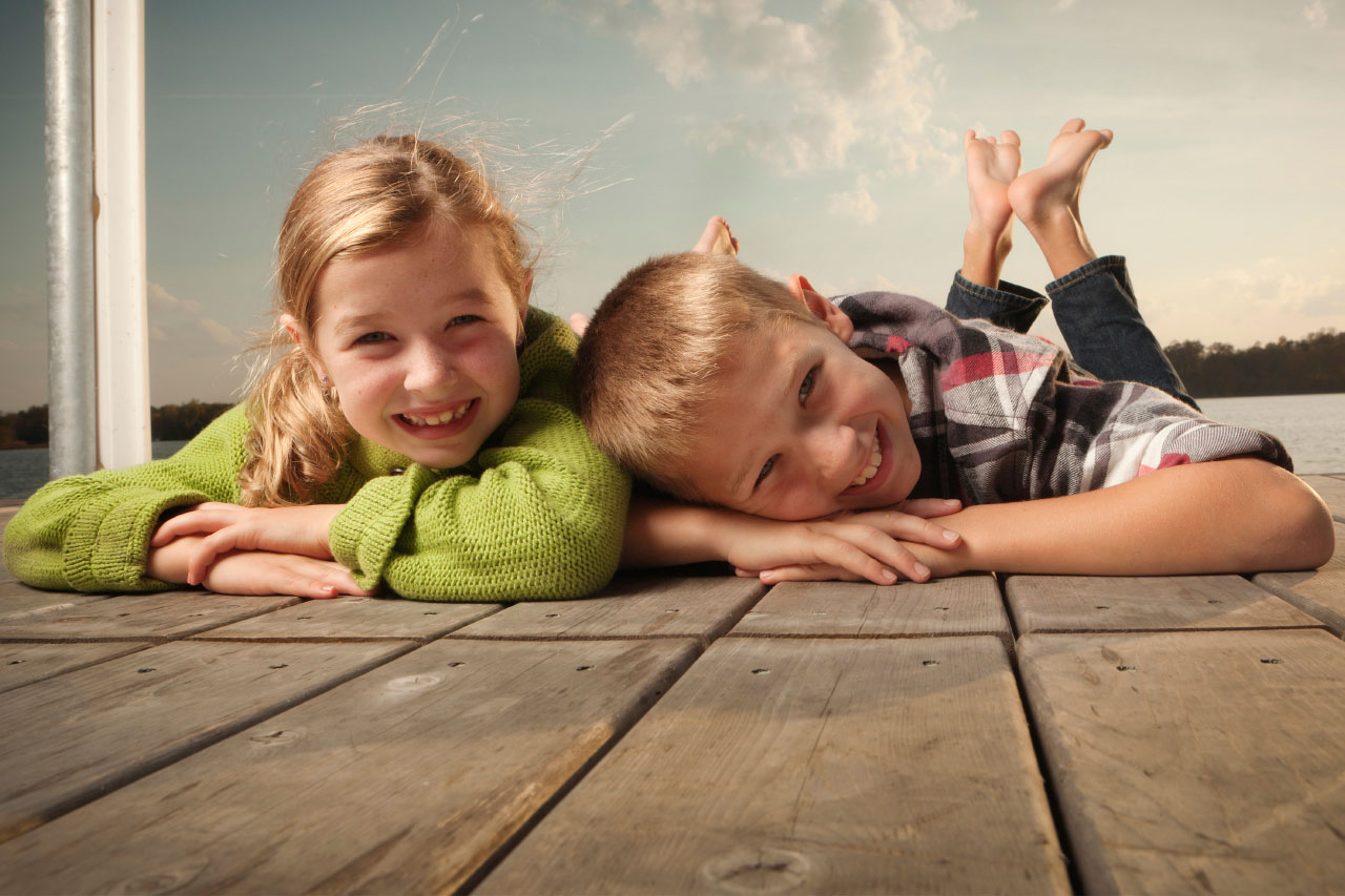 Children smiling on a pier